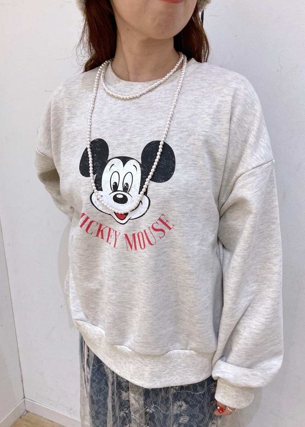 ブルー系のデニムパンツ、ホワイト系のスカート、ゴールド系のショルダーバッグを着用したレディースの秋コーディネートの7枚目の写真