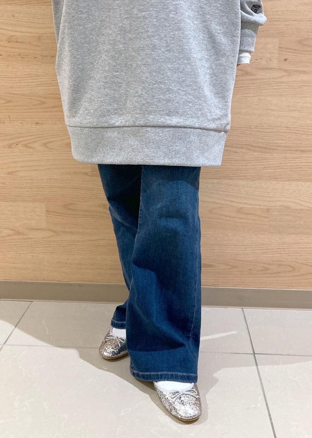 ホワイト系のTシャツ/カットソー、ブルー系のデニムパンツ、グレー系のワンピースを着用したレディースの秋コーディネートの8枚目の写真