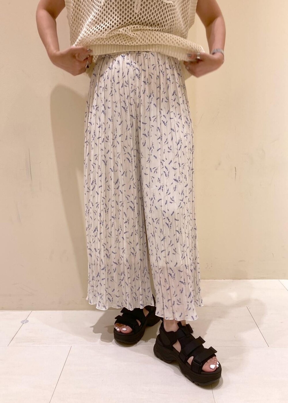 ホワイト系のニット/セーター、ホワイト系のその他パンツ、ブラック系のバックパック/リュックを着用したレディースの夏コーディネートの6枚目の写真