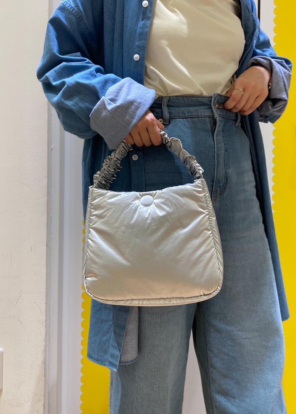 ホワイト系のTシャツ/カットソー、ブルー系のデニムパンツ、シルバー系のショルダーバッグを着用したレディースの春コーディネートの6枚目の写真