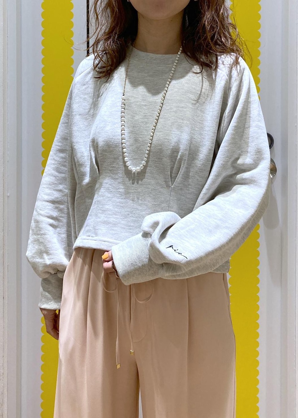 グレー系のスウェット、シルバー系のショルダーバッグ、ピンク系のその他パンツを着用したレディースの冬コーディネートの3枚目の写真