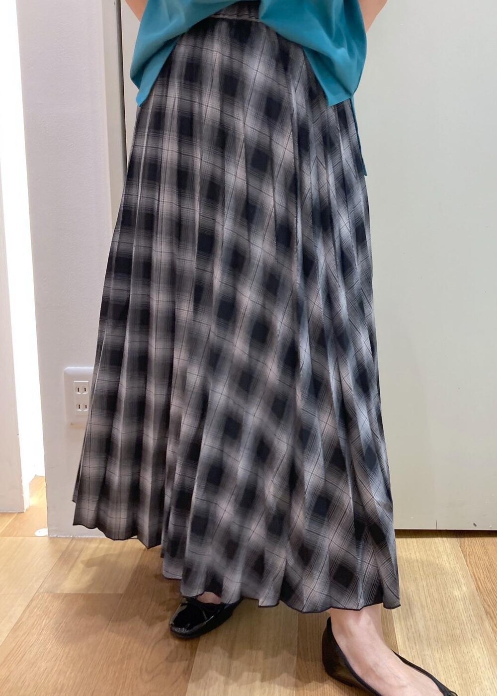 ブラック系のハンドバッグ、ブラック系のバレエシューズ、グリーン系のTシャツ/カットソーを着用したレディースの夏コーディネートの6枚目の写真