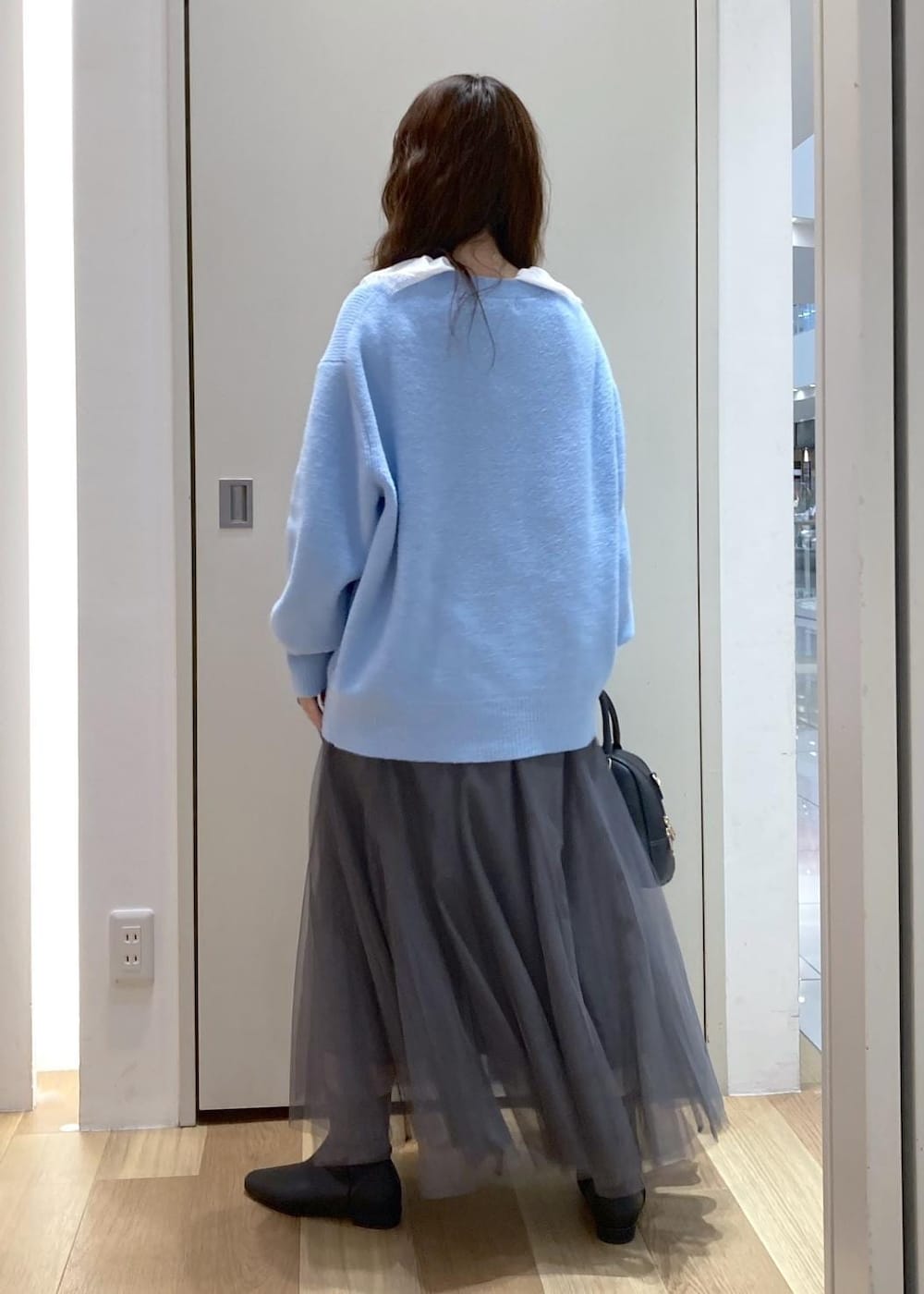 ブルー系のカーディガン/ボレロ、グレー系のスカート、ホワイト系のシャツ/ブラウスを着用したレディースの秋コーディネートの3枚目の写真