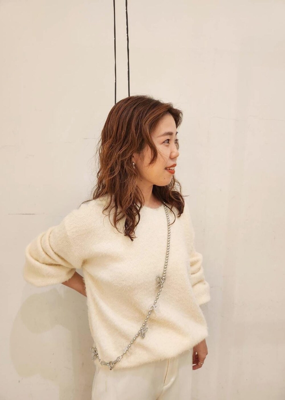 グレー系のパンプス、ホワイト系のニット/セーター、ホワイト系のその他パンツを着用したレディースの冬コーディネートの3枚目の写真