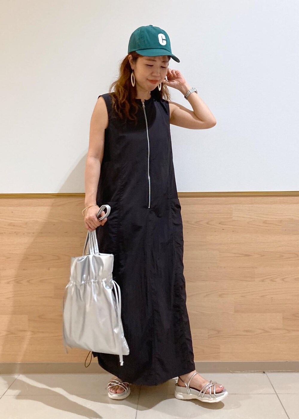 シルバー系のサンダル、ブラック系のワンピース、シルバー系のトートバッグを着用したレディースの夏コーディネートの2枚目の写真