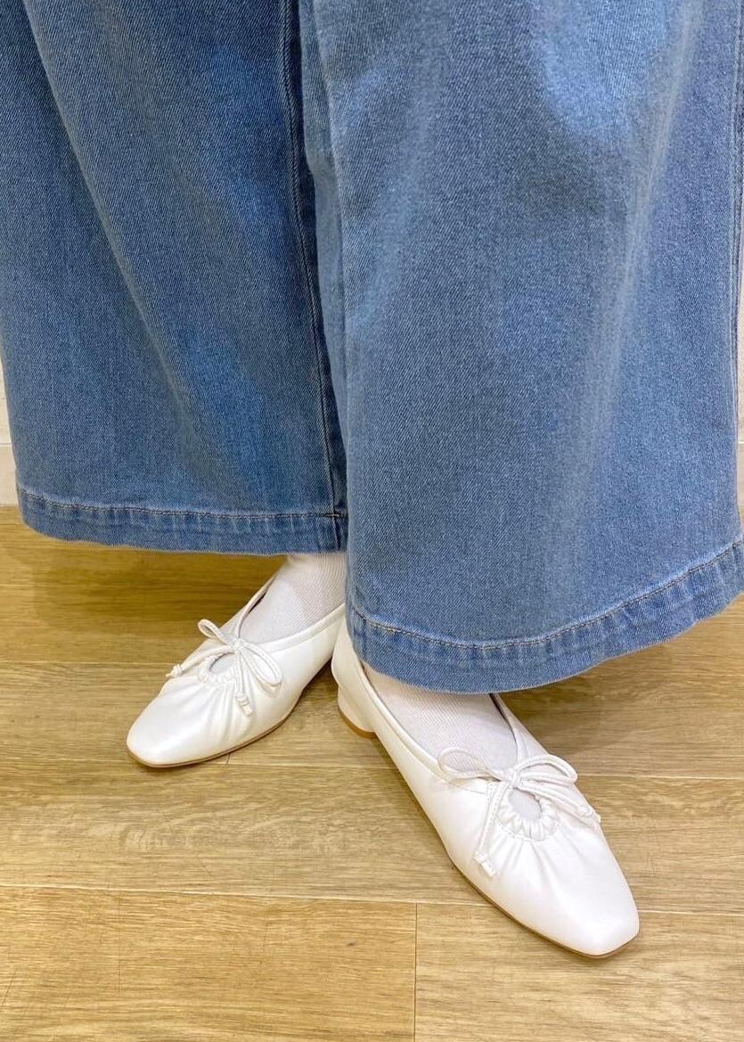 ブラック系のベスト、レッド系のTシャツ/カットソー、ホワイト系のパンプスを着用したレディースの春コーディネートの7枚目の写真