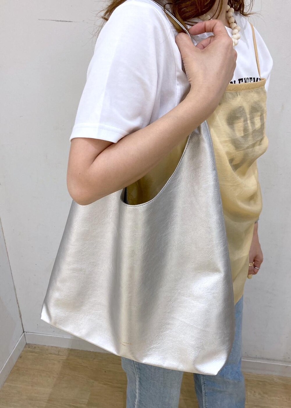ホワイト系のTシャツ/カットソー、ベージュ系のサンダル、オレンジ系のベストを着用したレディースの夏コーディネートの8枚目の写真