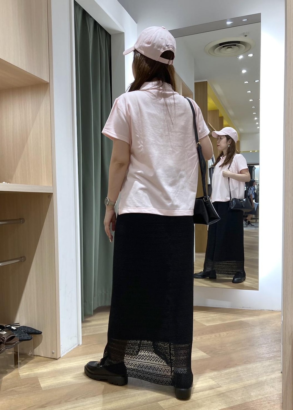 ブラック系のショルダーバッグ、ブラック系のローファー、ブラック系のスカートを着用したレディースの夏コーディネートの3枚目の写真