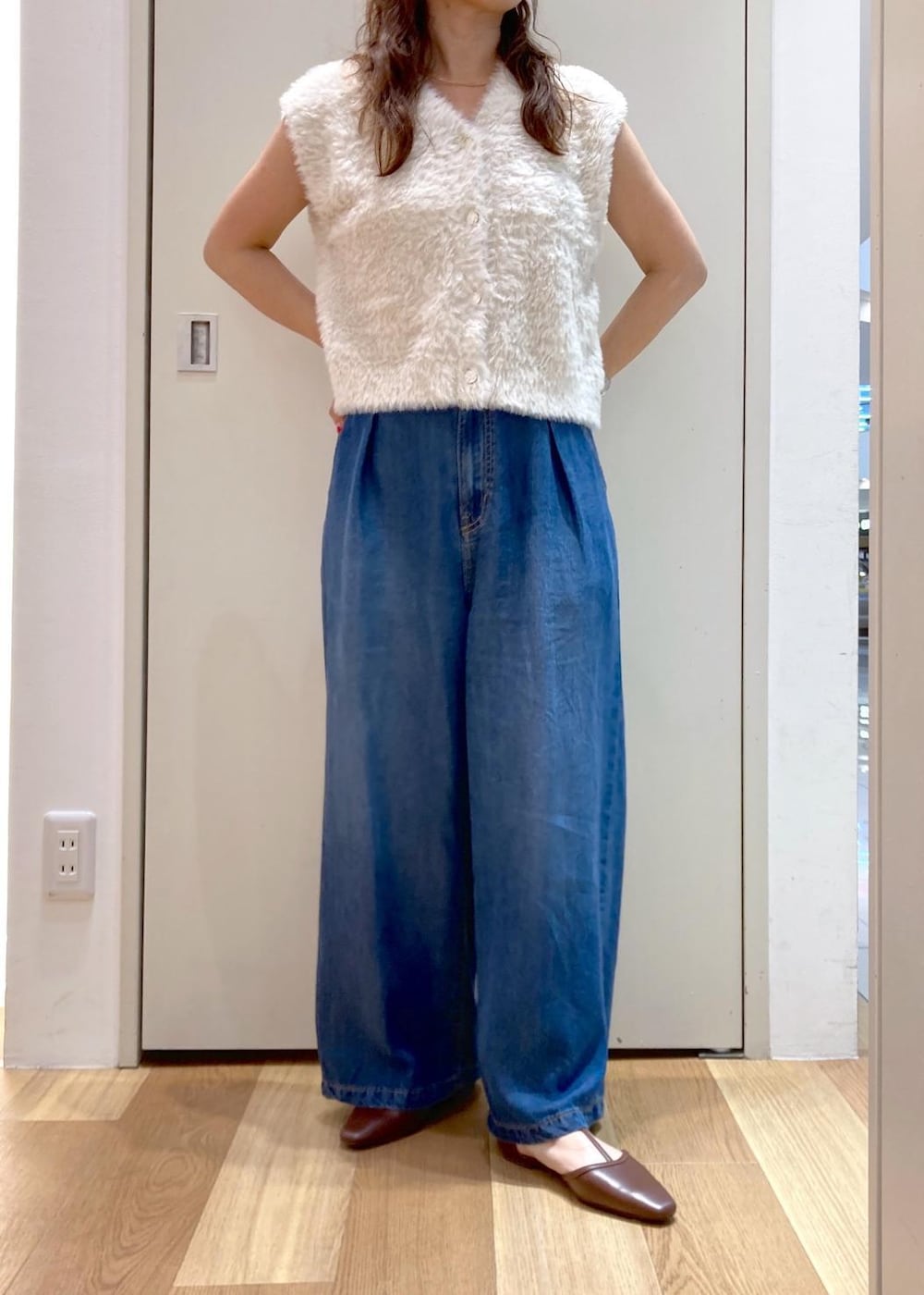 ブラウン系のパンプス、ブルー系のデニムパンツ、レッド系のトートバッグを着用したレディースの夏コーディネートの5枚目の写真