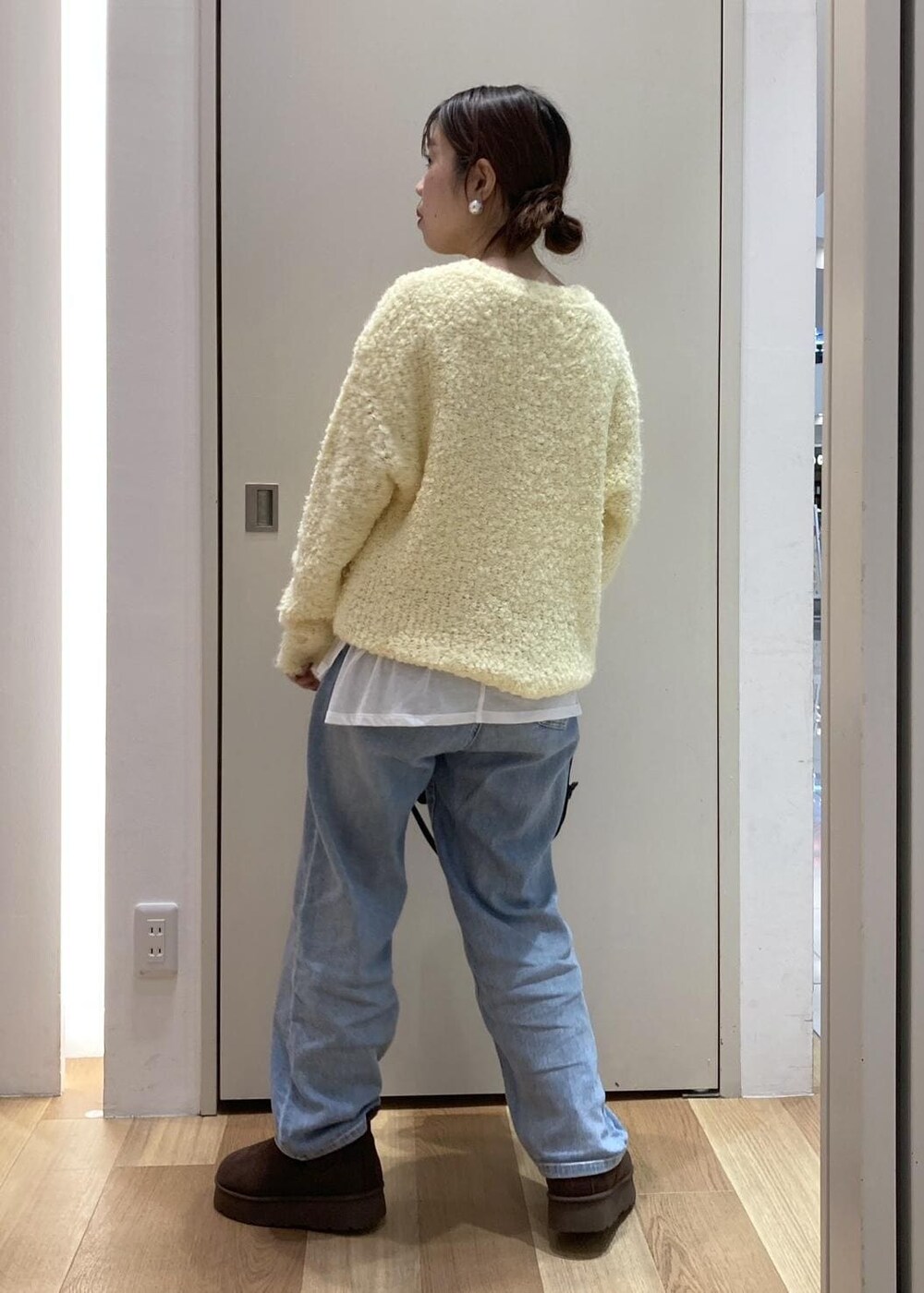 ホワイト系のTシャツ/カットソー、イエロー系のニット/セーター、ブラウン系のブーツを着用したレディースの冬コーディネートの3枚目の写真