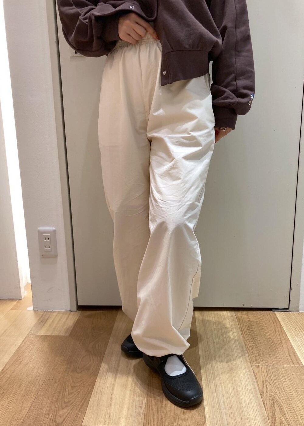 ブラック系のスニーカー、ホワイト系のその他パンツ、ブラウン系のカーディガン/ボレロを着用したレディースの秋コーディネートの6枚目の写真