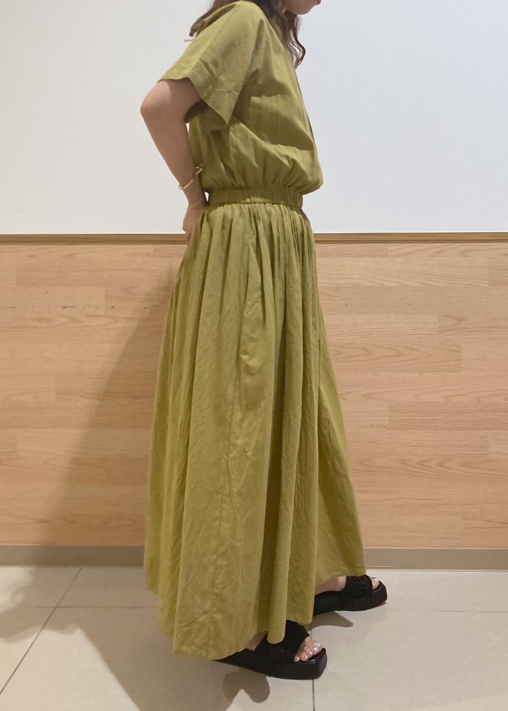 ブラック系のサンダル、ブラック系のかごバッグ、イエロー系のワンピースを着用したレディースの夏コーディネートの2枚目の写真