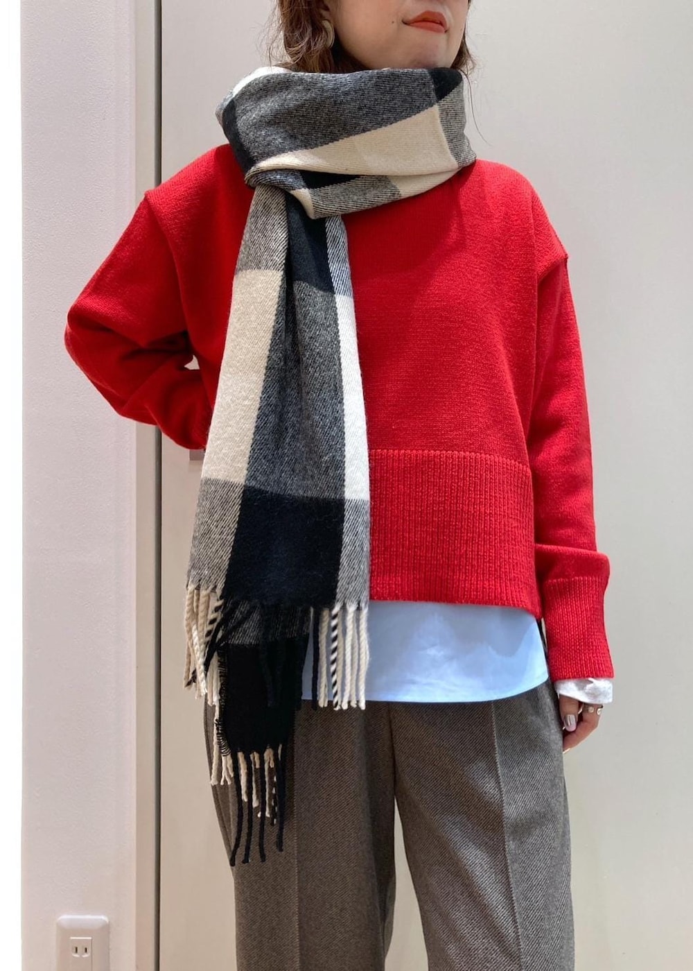 レッド系のニット/セーター、レッド系のブーツ、グレー系のトートバッグを着用したレディースの秋コーディネートの6枚目の写真