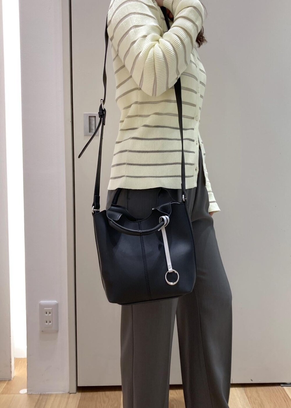 グレー系のスラックス、ベージュ系のカーディガン/ボレロ、ブラック系のバレエシューズを着用したレディースの春コーディネートの7枚目の写真