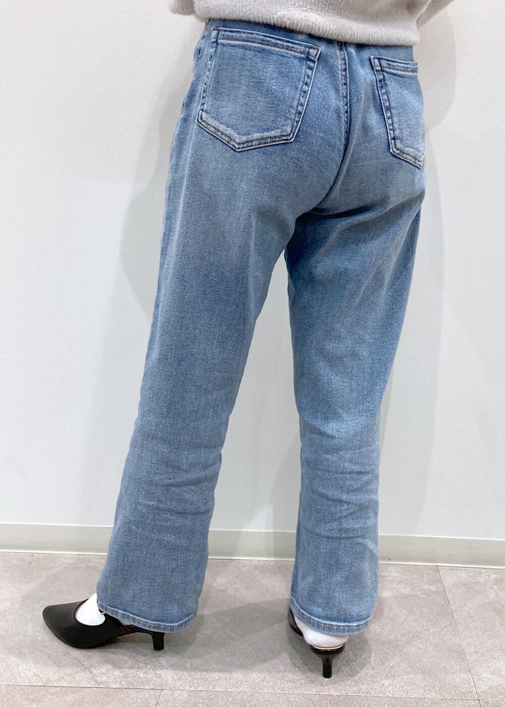 ブルー系のシャツ/ブラウス、ブラック系のパンプス、ブルー系のデニムパンツを着用したレディースの冬コーディネートの6枚目の写真