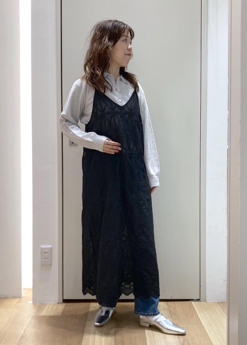 ホワイト系のボストンバッグ、ブルー系のデニムパンツ、ブラック系のワンピースを着用したレディースの春コーディネートの6枚目の写真