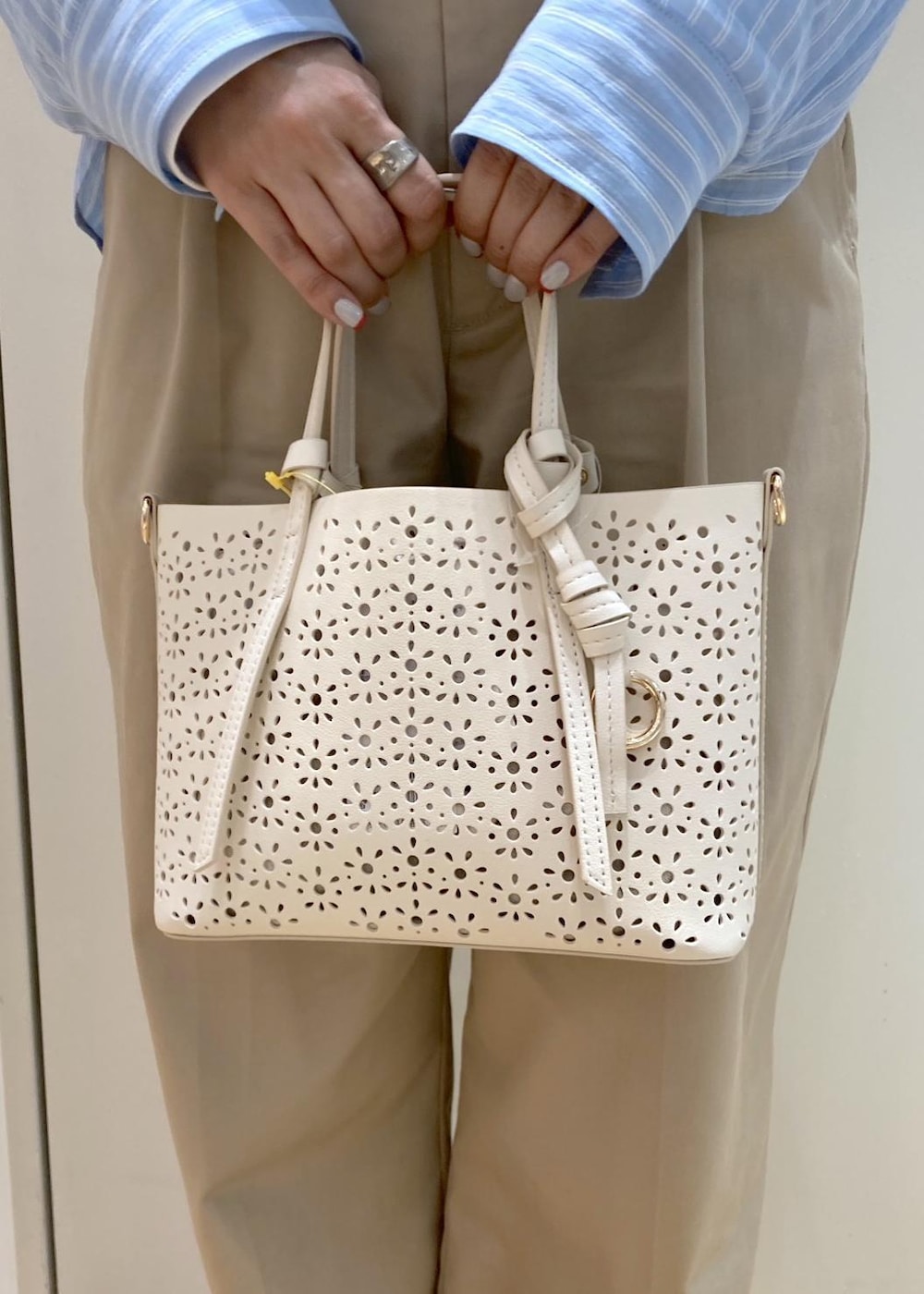 ベージュ系のチノパンツ、ブラック系のサンダル、ホワイト系のショルダーバッグを着用したレディースの春コーディネートの7枚目の写真