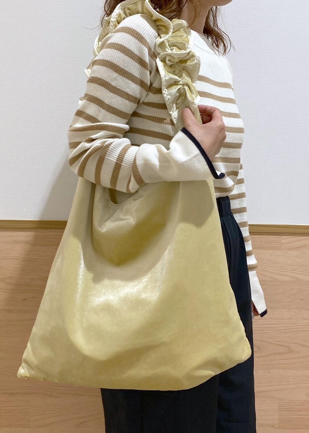 イエロー系のショルダーバッグ、ベージュ系のニット/セーター、ベージュ系のベストを着用したレディースの秋コーディネートの8枚目の写真