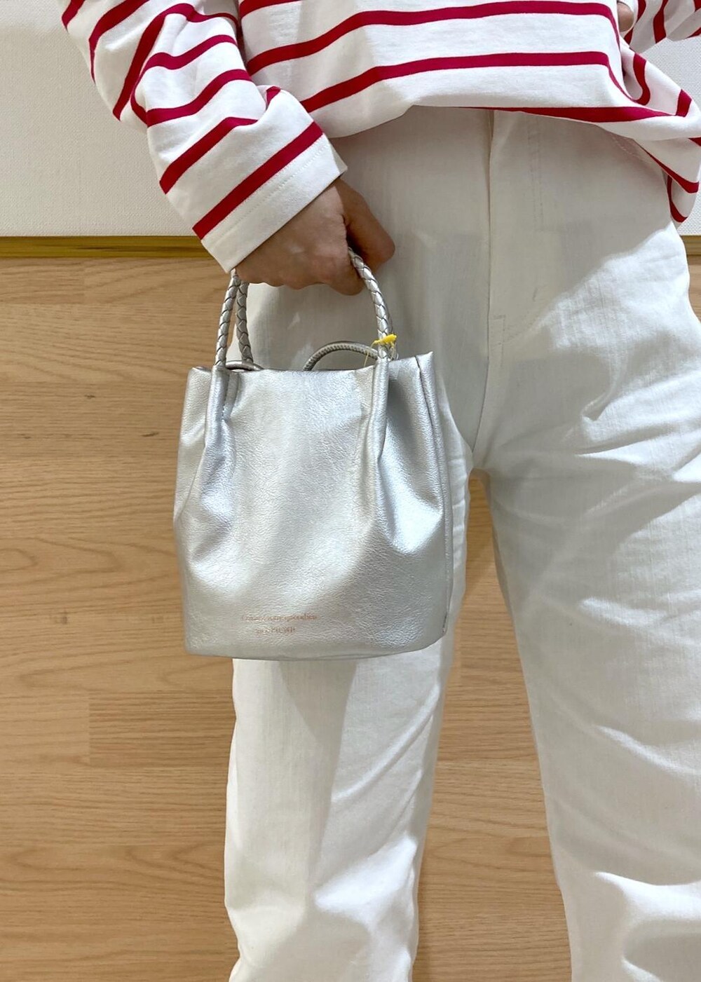 ベージュ系のトレンチコート、レッド系のTシャツ/カットソー、ホワイト系のデニムパンツを着用したレディースの春コーディネートの5枚目の写真