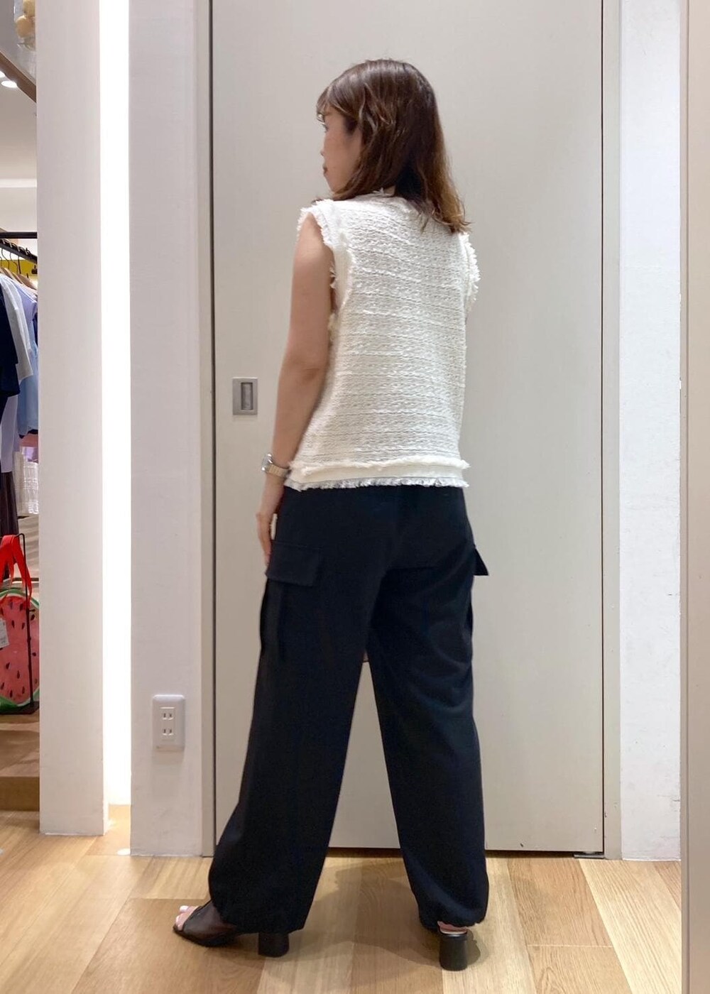 ピンク系のボストンバッグ、ブラック系のパンプス、ブラック系のカーゴパンツを着用したレディースの夏コーディネートの4枚目の写真