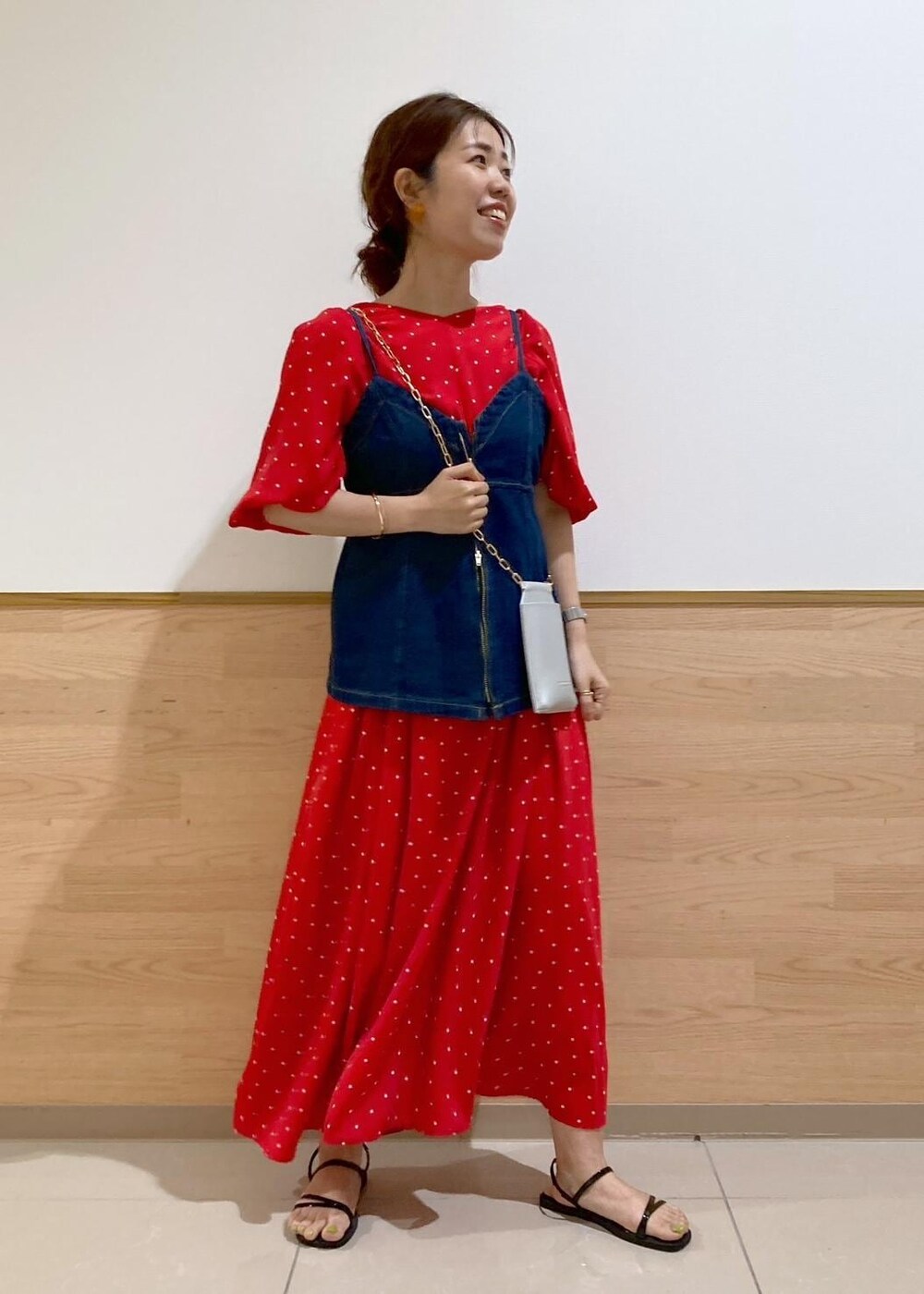 ブラック系のサンダル、シルバー系のショルダーバッグ、ブルー系のベストを着用したレディースの春コーディネートの2枚目の写真