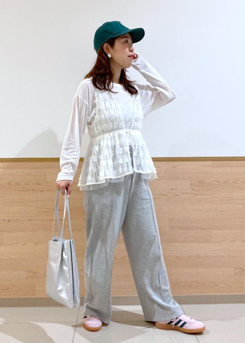 ホワイト系のベスト、シルバー系のトートバッグ、グレー系のその他パンツを着用したレディースの春コーディネートの2枚目の写真