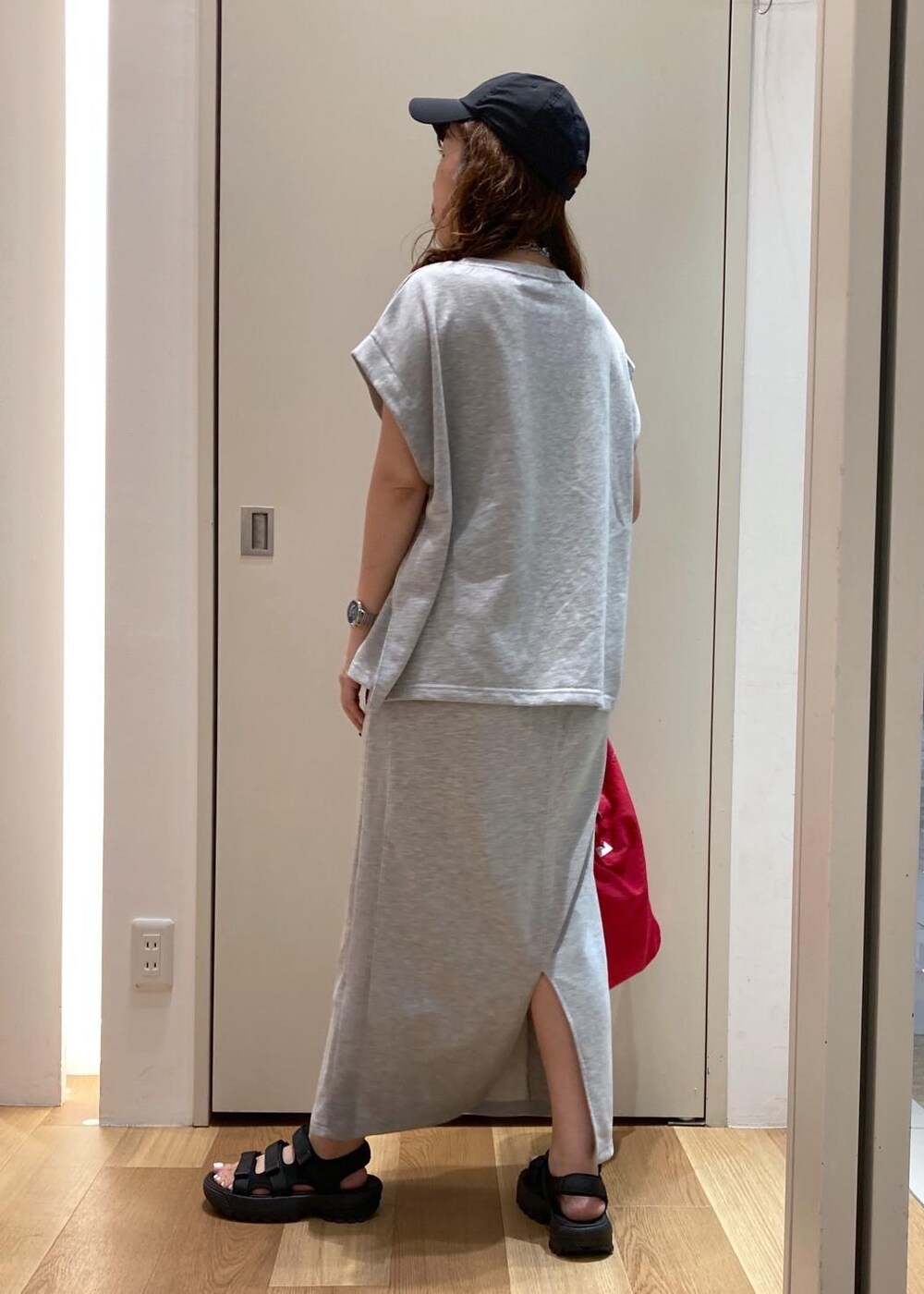 ブラック系のサンダル、レッド系のトートバッグ、グレー系のスカートを着用したレディースの夏コーディネートの3枚目の写真