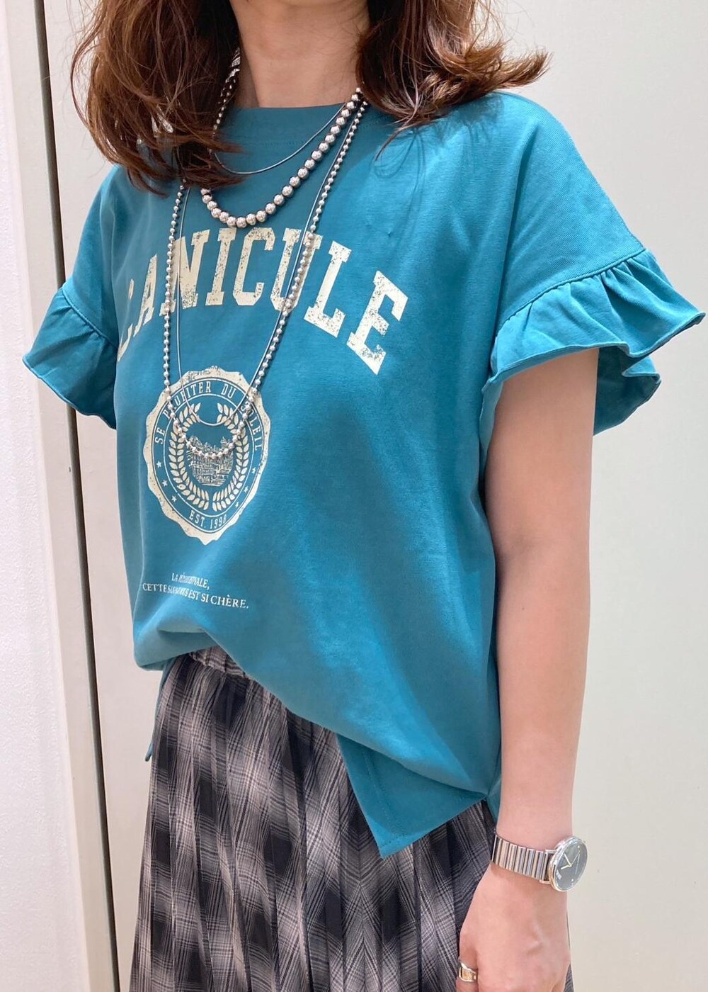 ブラック系のハンドバッグ、ブラック系のバレエシューズ、グリーン系のTシャツ/カットソーを着用したレディースの夏コーディネートの5枚目の写真