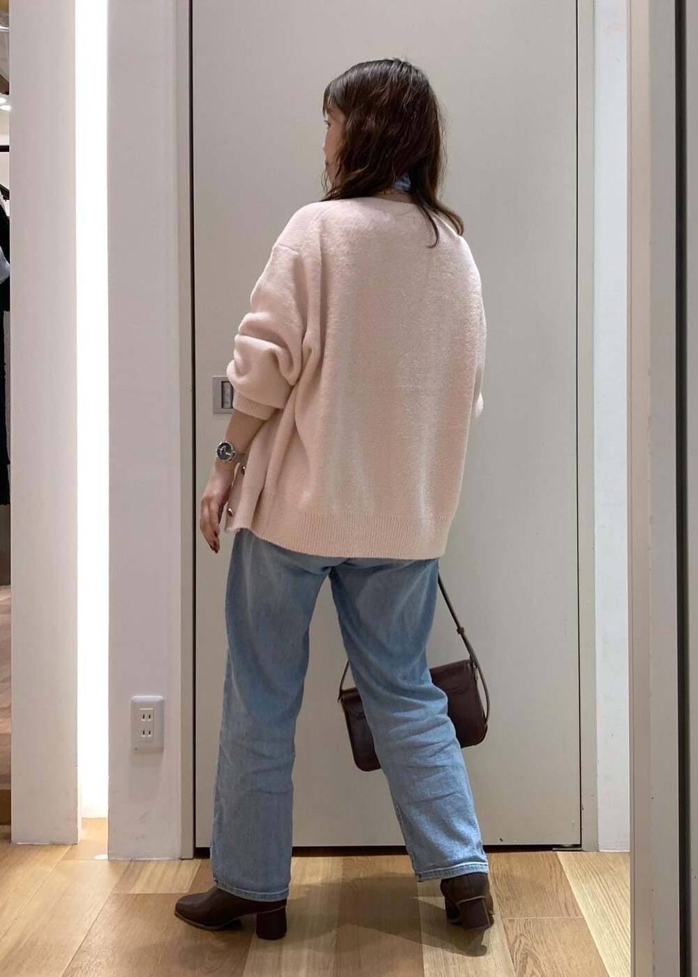 ピンク系のカーディガン/ボレロ、ホワイト系のTシャツ/カットソー、ブラウン系のブーツを着用したレディースの秋コーディネートの3枚目の写真