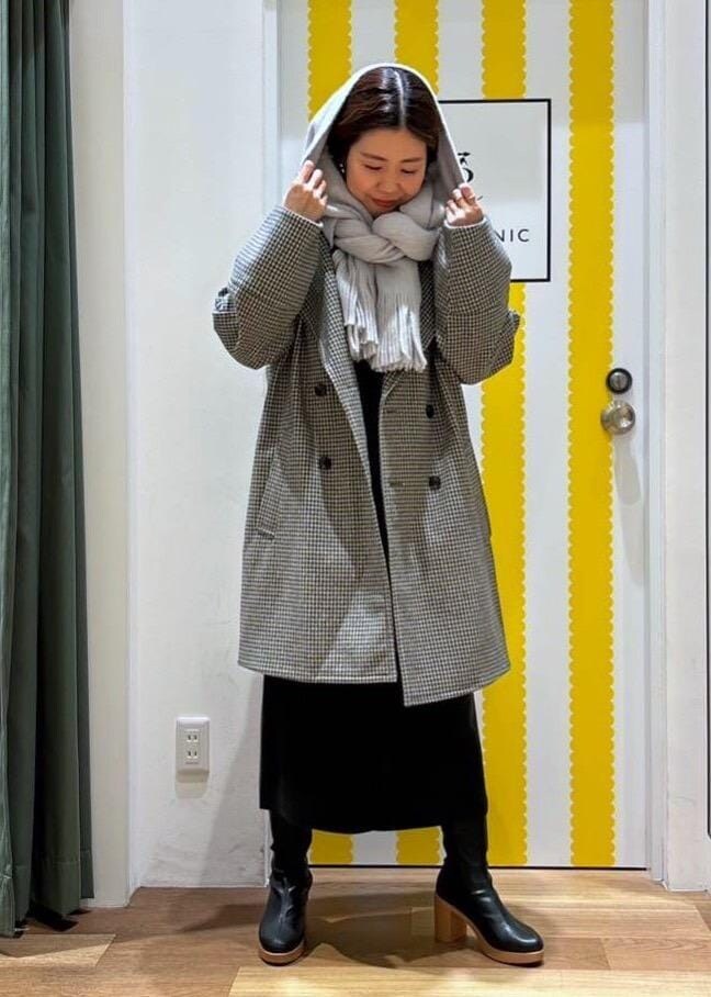 グレー系のジャンパースカート、レッド系のニット/セーター、ブラック系のブーツを着用したレディースの冬コーディネートの4枚目の写真