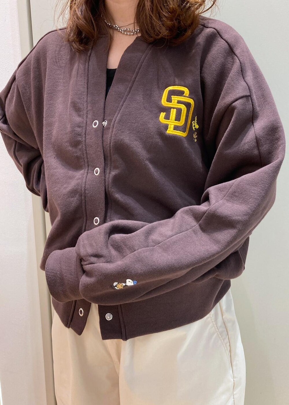 ブラック系のスニーカー、ホワイト系のその他パンツ、ブラウン系のカーディガン/ボレロを着用したレディースの秋コーディネートの4枚目の写真