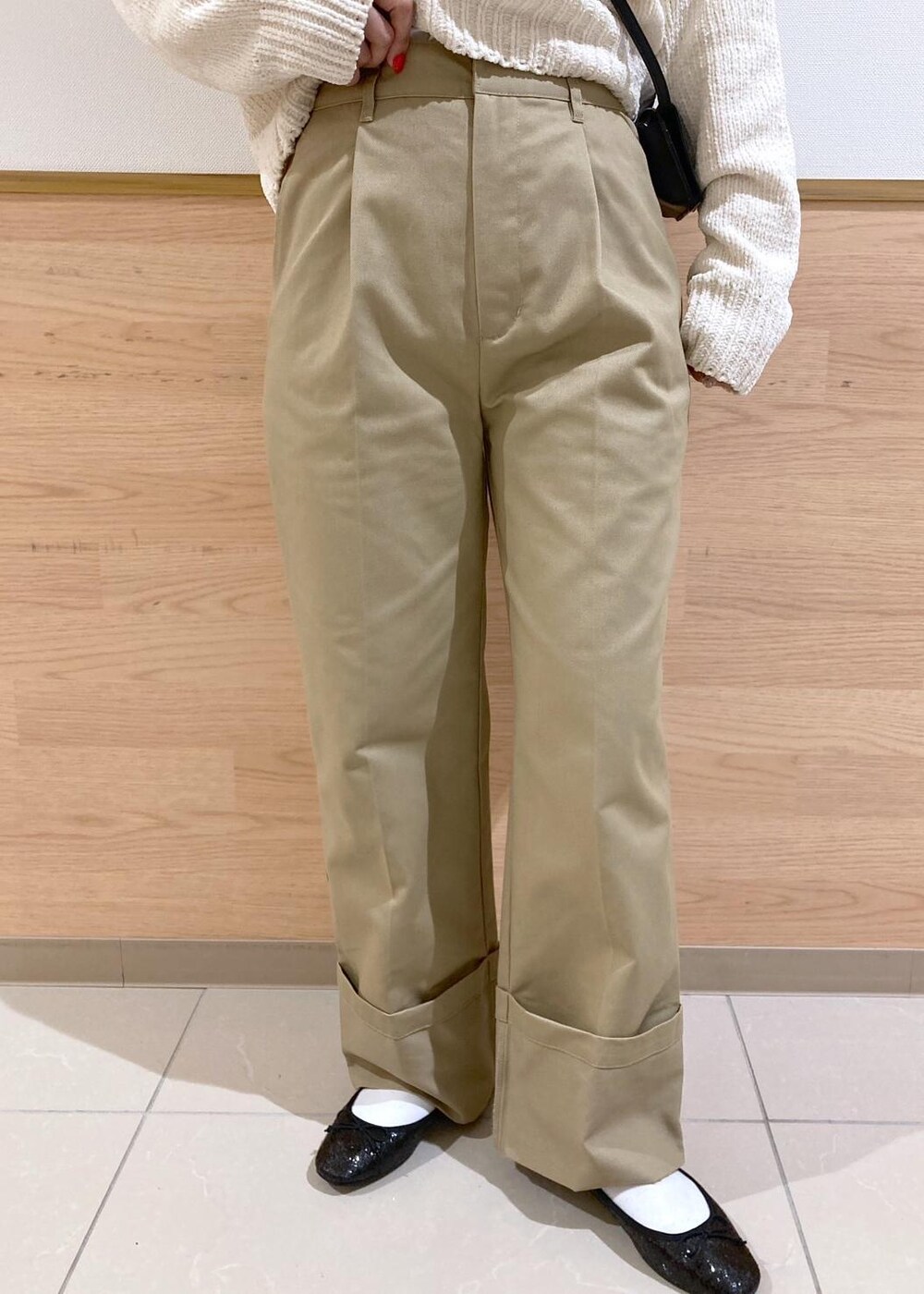 ホワイト系のニット/セーター、ブラック系のバレエシューズ、ベージュ系のチノパンツを着用したレディースの冬コーディネートの6枚目の写真