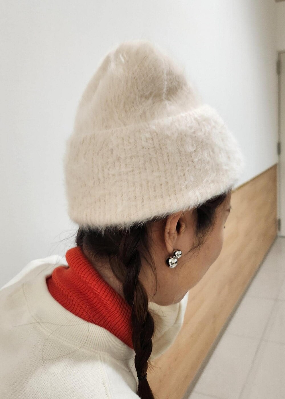 レッド系のニット/セーター、ホワイト系のダウンジャケット/コート、ブラック系のトートバッグを着用したレディースの冬コーディネートの7枚目の写真