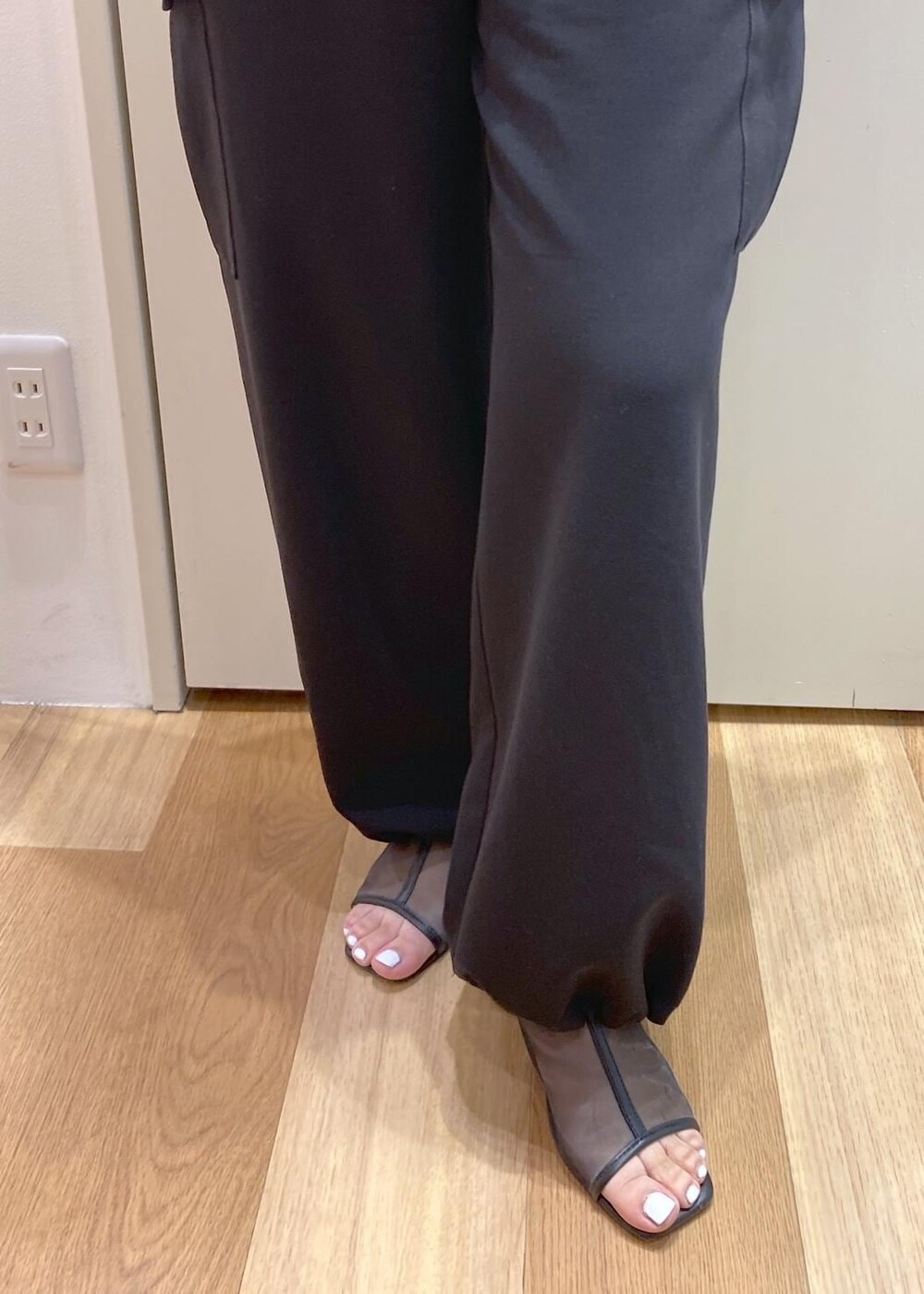 ピンク系のボストンバッグ、ブラック系のパンプス、ブラック系のカーゴパンツを着用したレディースの夏コーディネートの7枚目の写真