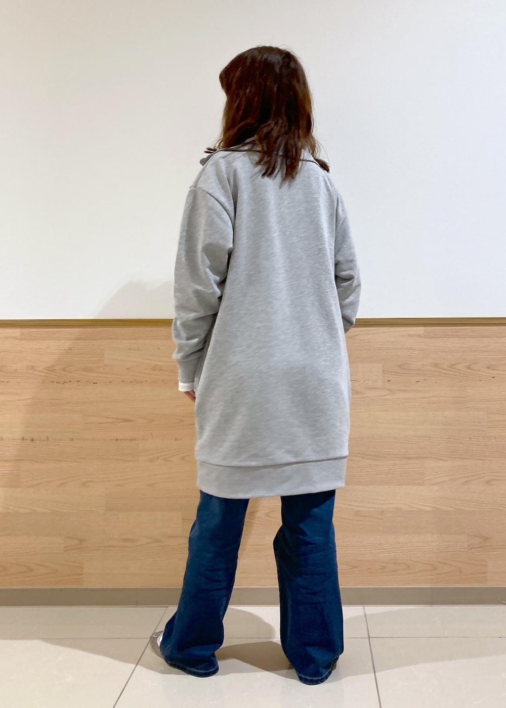 ホワイト系のTシャツ/カットソー、ブルー系のデニムパンツ、グレー系のワンピースを着用したレディースの秋コーディネートの4枚目の写真