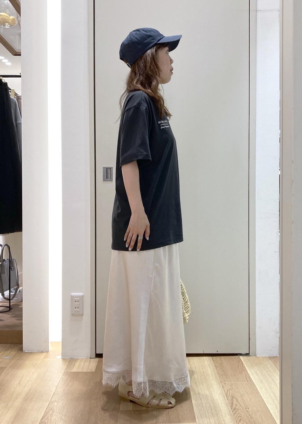 ベージュ系のサンダル、ホワイト系のスカート、ベージュ系のトートバッグを着用したレディースの春コーディネートの2枚目の写真