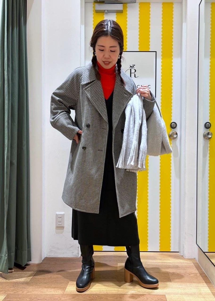 グレー系のジャンパースカート、レッド系のニット/セーター、ブラック系のブーツを着用したレディースの冬コーディネートの3枚目の写真