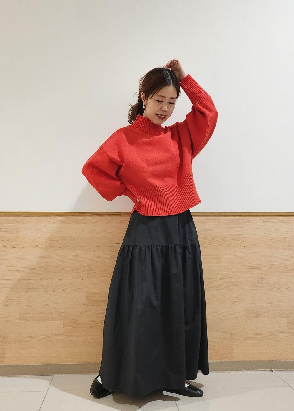 ブラック系のショルダーバッグ、レッド系のニット/セーター、ブラック系のスカートを着用したレディースの秋コーディネートの4枚目の写真