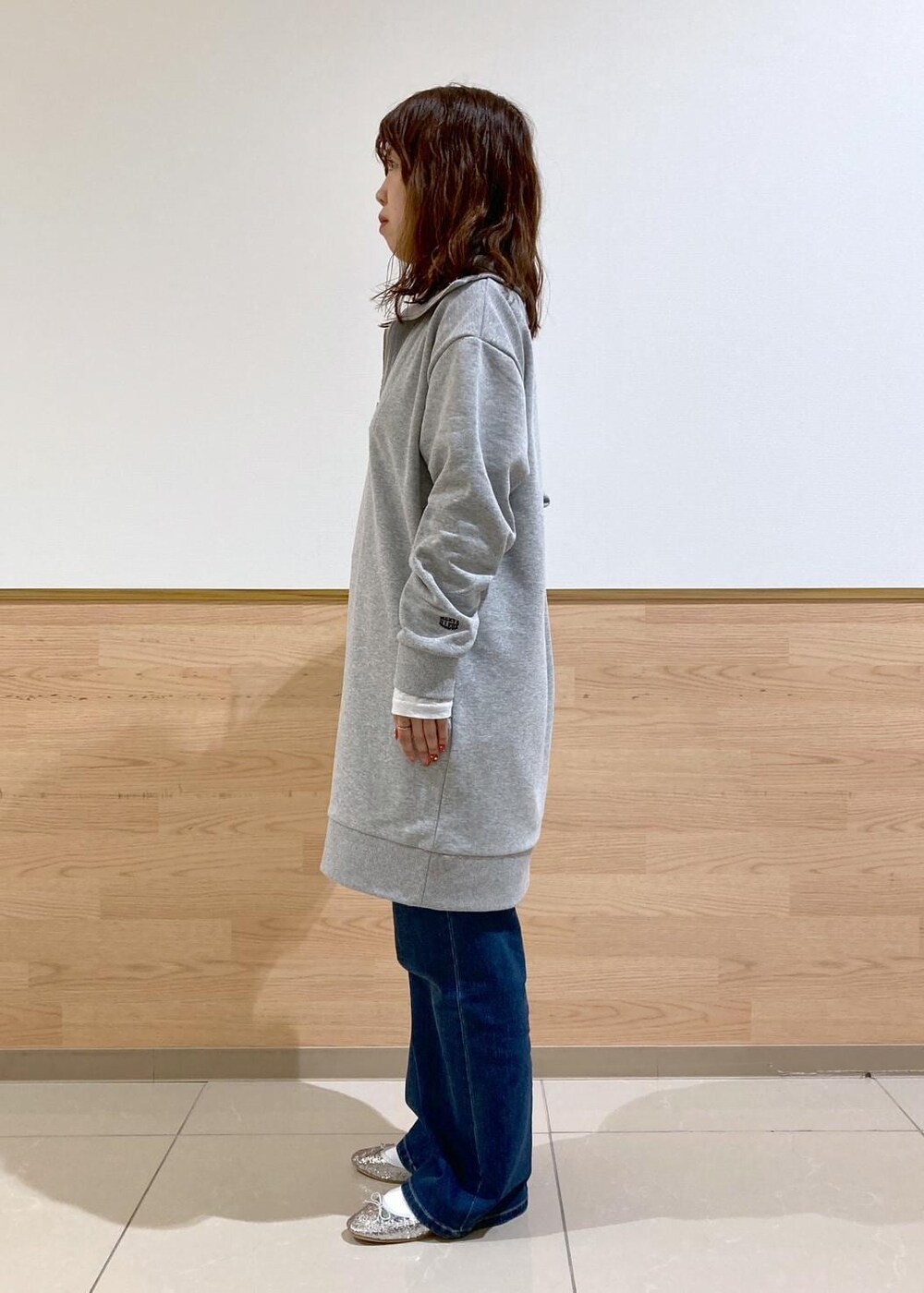 ホワイト系のTシャツ/カットソー、ブルー系のデニムパンツ、グレー系のワンピースを着用したレディースの秋コーディネートの3枚目の写真