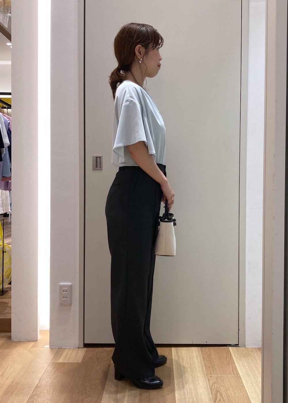 ブラック系のローファー、グレー系のその他パンツ、ブラック系のトートバッグを着用したレディースの夏コーディネートの2枚目の写真