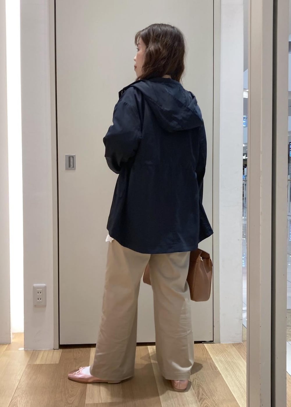 ベージュ系のチノパンツ、イエロー系のトートバッグ、ホワイト系のニット/セーターを着用したレディースの春コーディネートの3枚目の写真