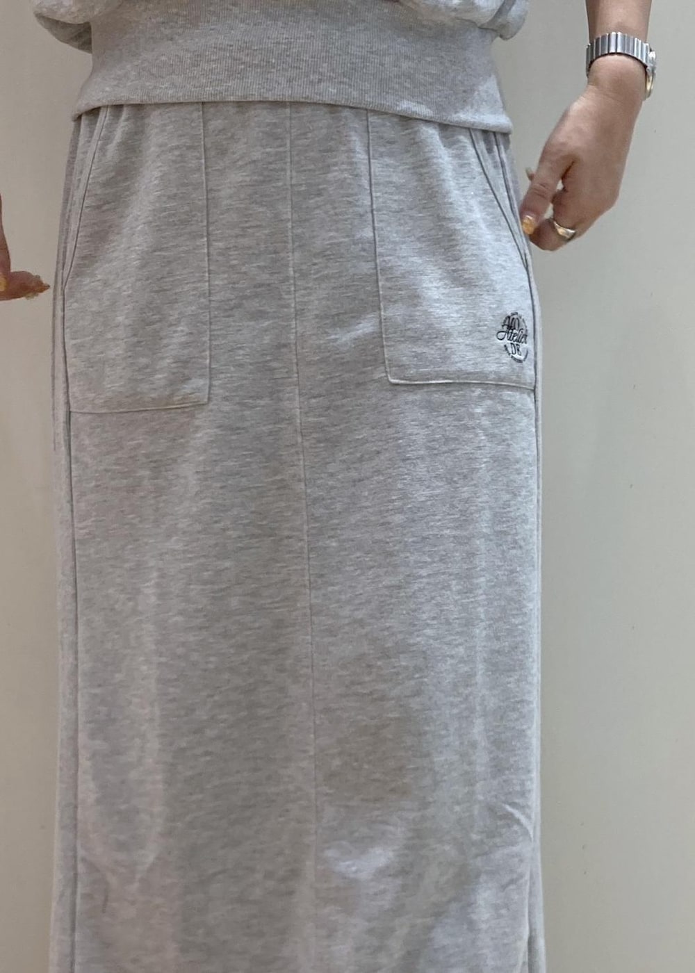 ブラック系のサンダル、グレー系のスカート、グレー系のTシャツ/カットソーを着用したレディースの夏コーディネートの7枚目の写真