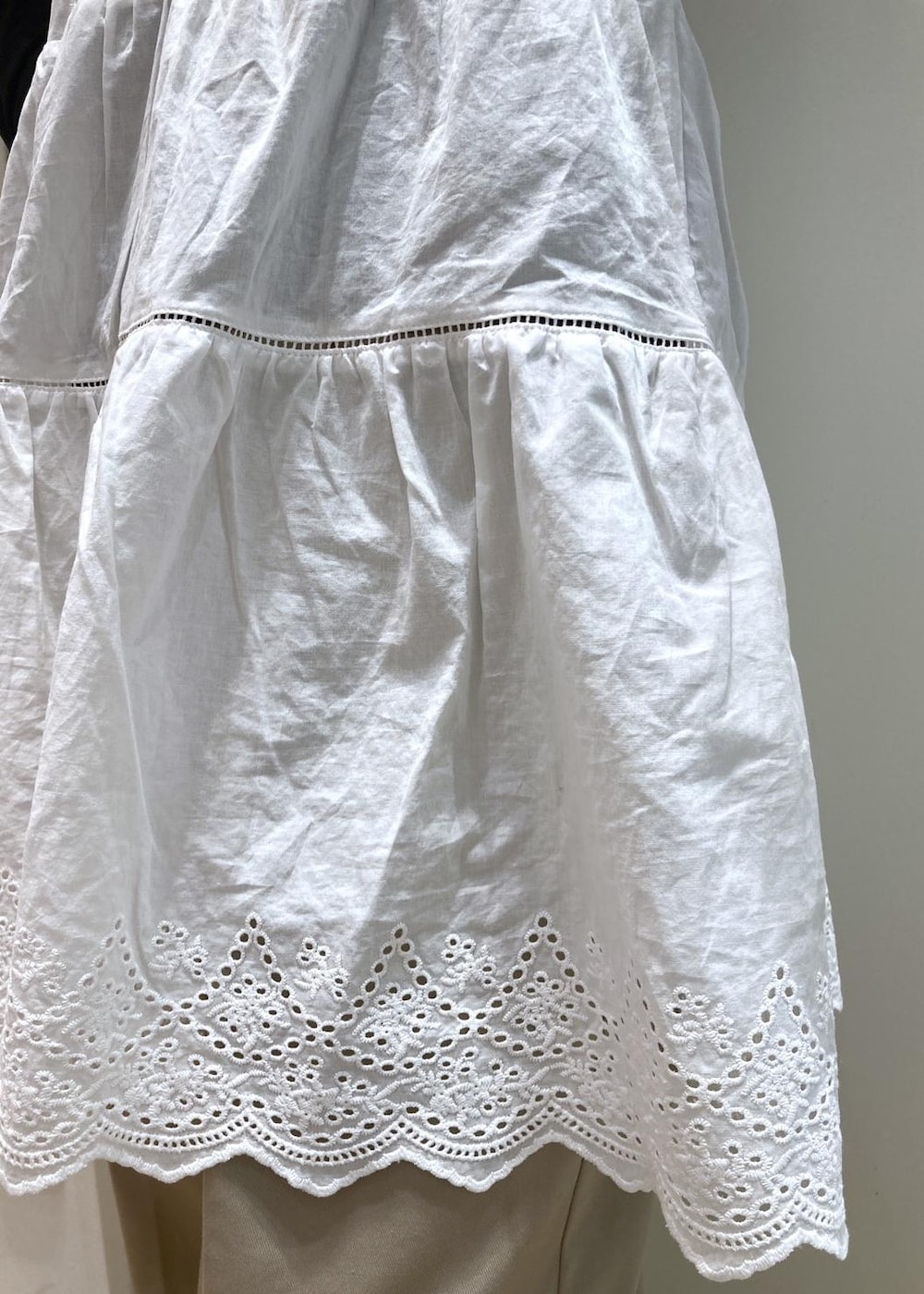 ホワイト系のキャミソール、ベージュ系のチノパンツ、ブラウン系のボストンバッグを着用したレディースの冬コーディネートの8枚目の写真