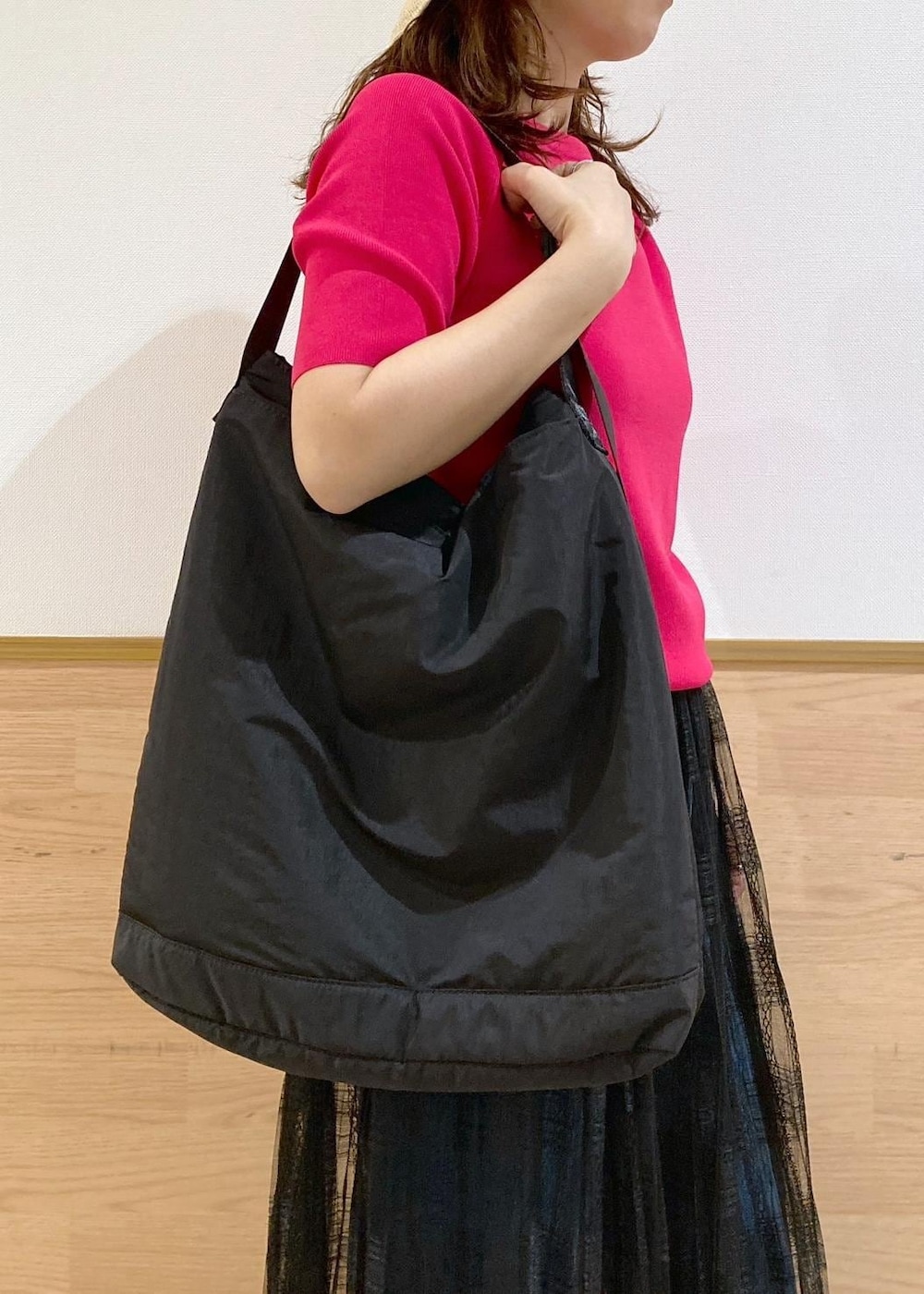 ブルー系のデニムパンツ、ブラック系のスカート、ブラック系のトートバッグを着用したレディースの春コーディネートの8枚目の写真