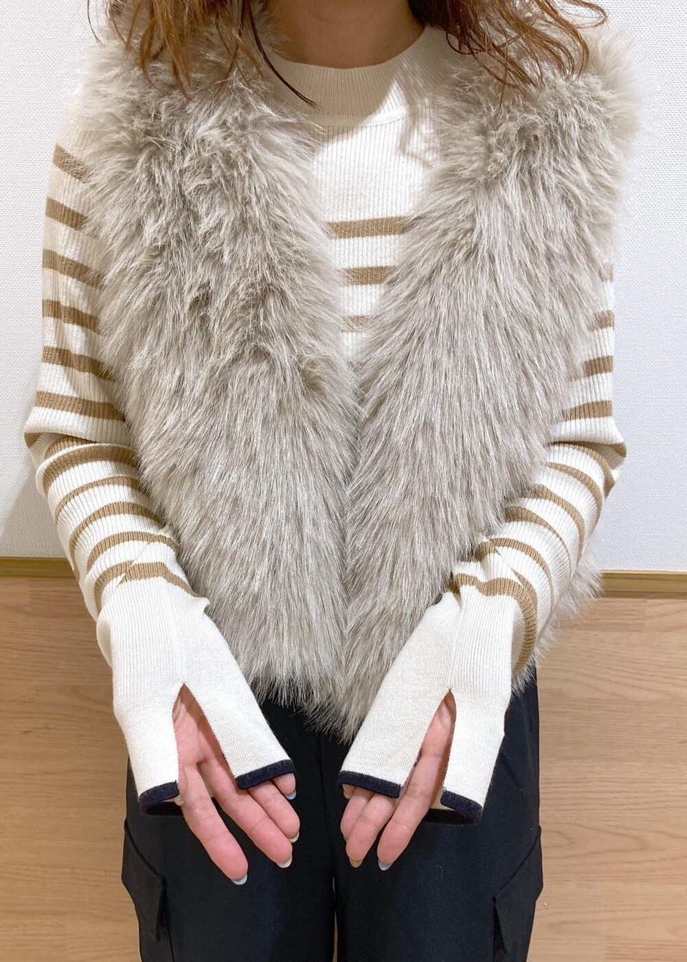 イエロー系のショルダーバッグ、ベージュ系のニット/セーター、ベージュ系のベストを着用したレディースの秋コーディネートの6枚目の写真