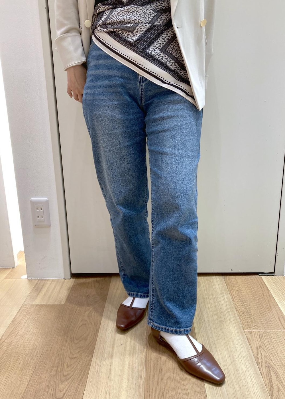 ブラウン系のボストンバッグ、ブルー系のデニムパンツ、ブラウン系のパンプスを着用したレディースの春コーディネートの7枚目の写真