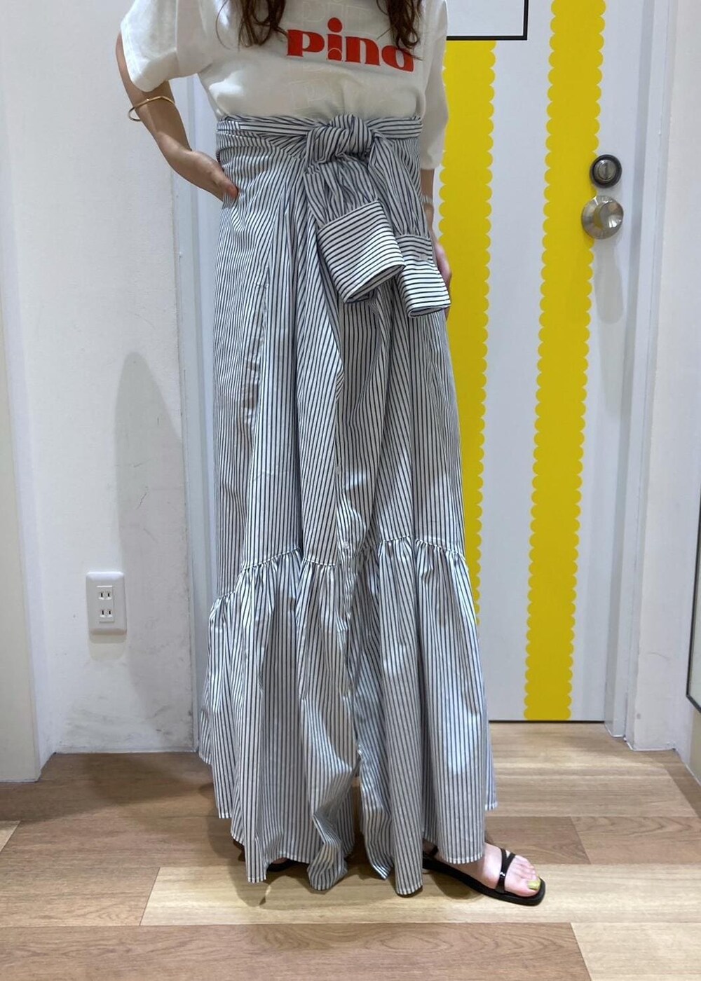 ブラック系のサンダル、ホワイト系のショルダーバッグ、ブルー系のシャツワンピースを着用したレディースの春コーディネートの4枚目の写真