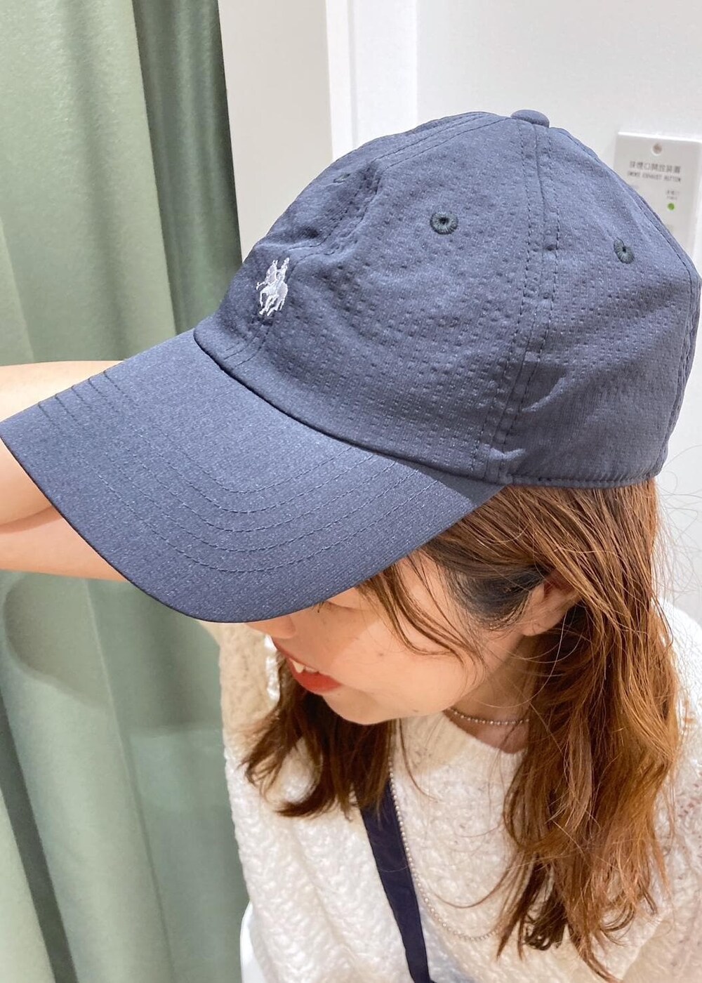 ホワイト系のワンピース、ブラック系のレインシューズ、ホワイト系のベストを着用したレディースの春コーディネートの8枚目の写真