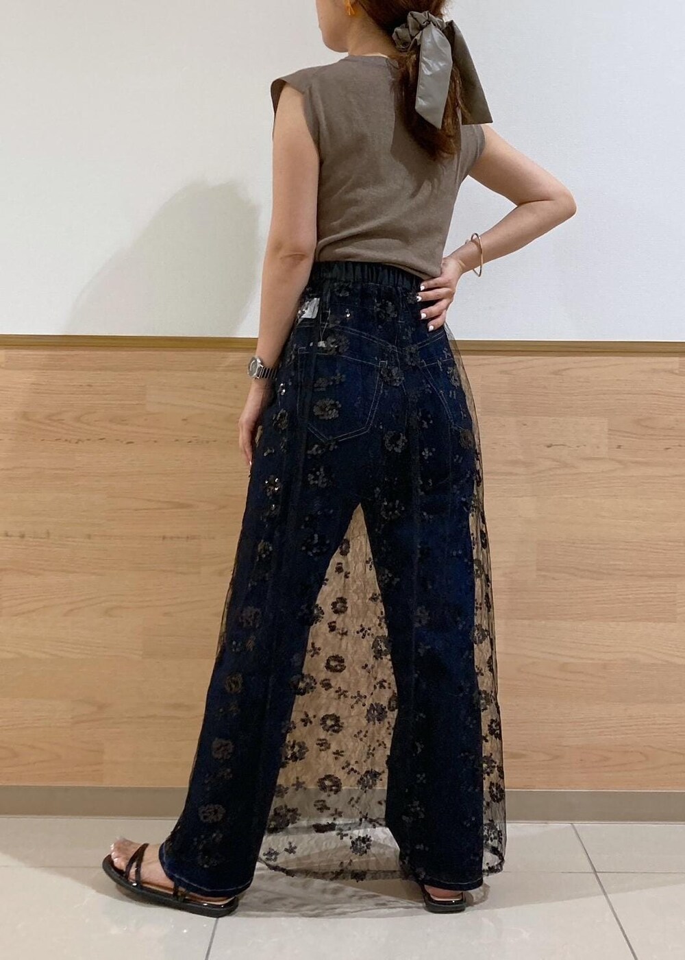 ブルー系のデニムパンツ、ブラック系のサンダル、ブラック系のスカートを着用したレディースの夏コーディネートの3枚目の写真