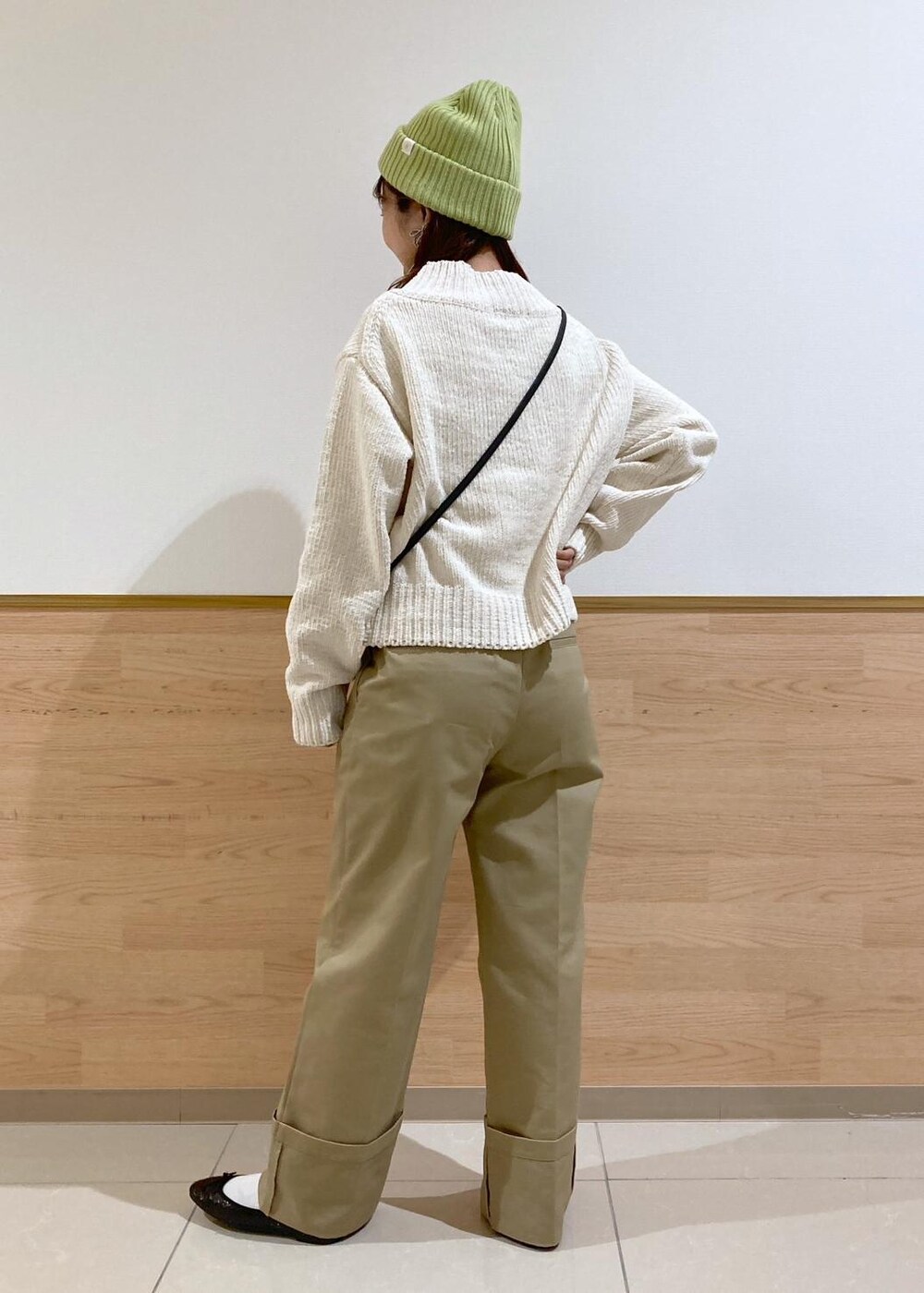 ホワイト系のニット/セーター、ブラック系のバレエシューズ、ベージュ系のチノパンツを着用したレディースの冬コーディネートの3枚目の写真